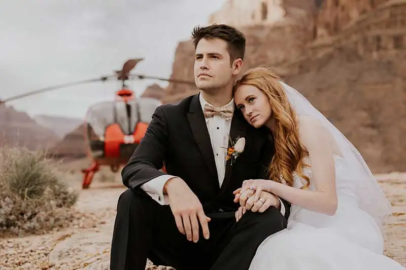 Grand Canyon Helicopter Wedding - Couple sitting in front of helicopter