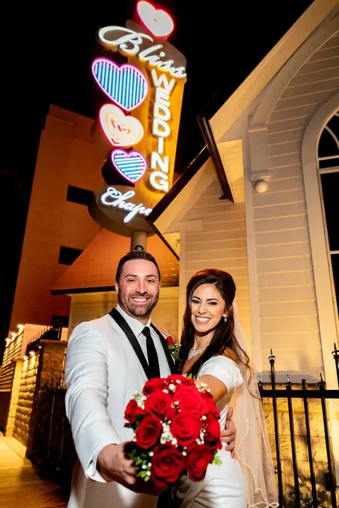 Couple in front of Bliss Wedding Chapel & Sign